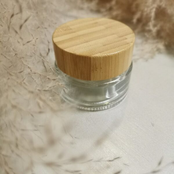 kosmetikka purkki bambukorkilla heinän ympäröimänä pöydällä