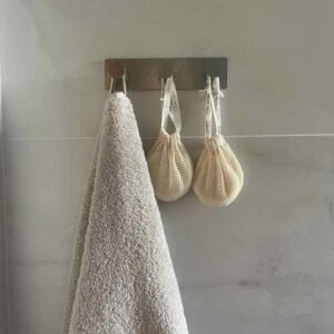 shampoo palat roikkuvat säilytys pusseista kylpyhuoneen naulakosta ja pyyhe vieressä